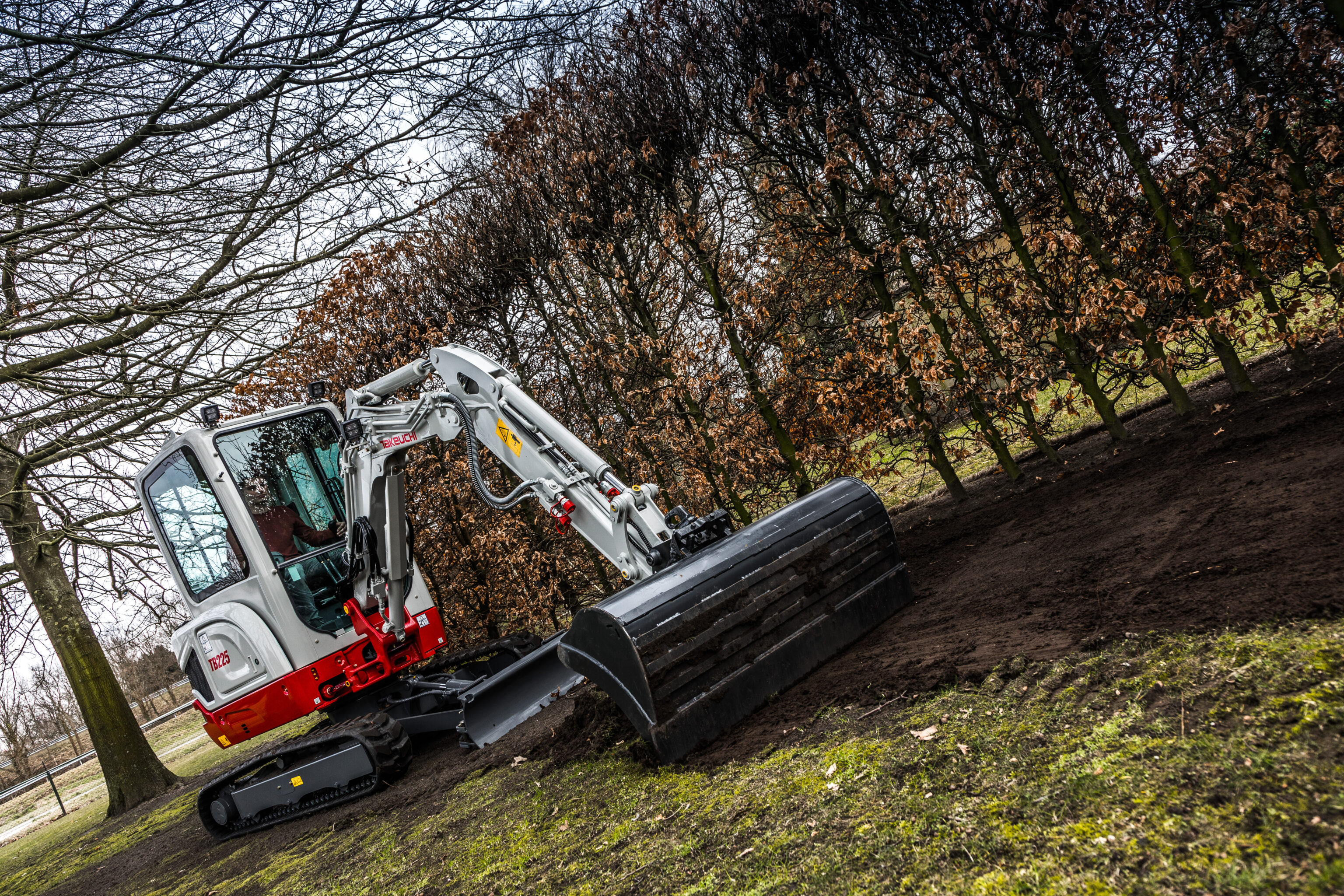 Takeuchi TB225 minigraver aan de slag in een tuin