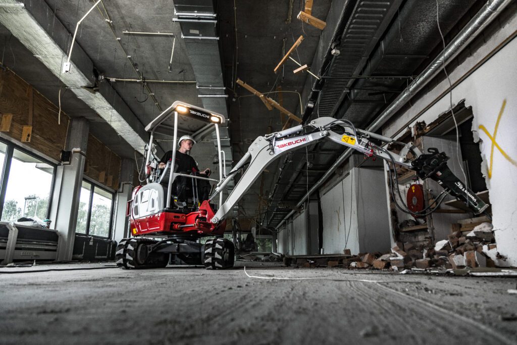 Takeuchi hybride minigraver sloopt muur met sloophamer