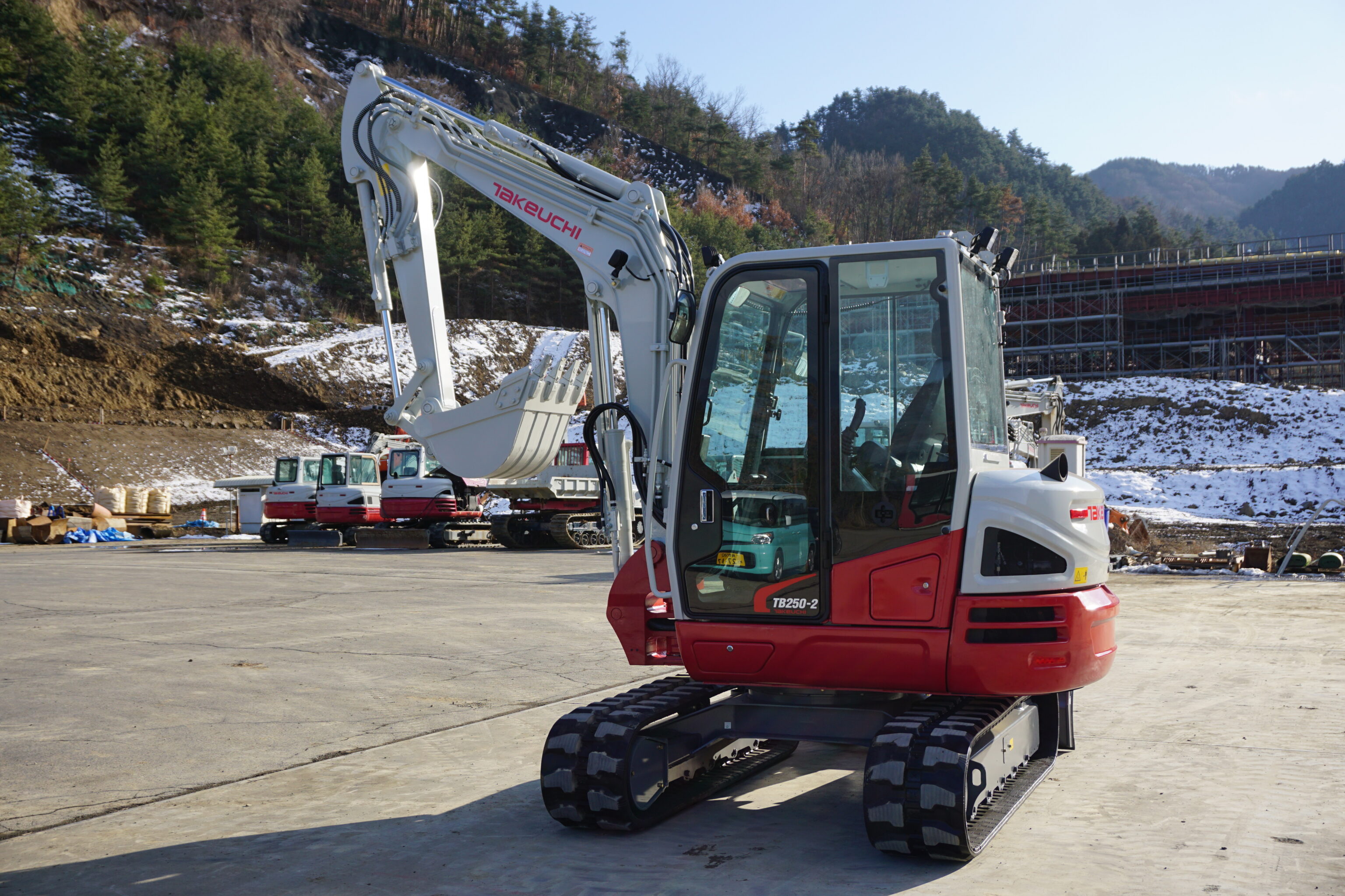 Takeuchi graafmachine zijkant in de sneeuw in de bergen