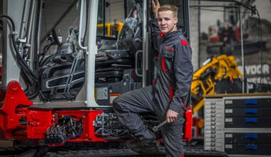 Monteur poserend bij minigraver