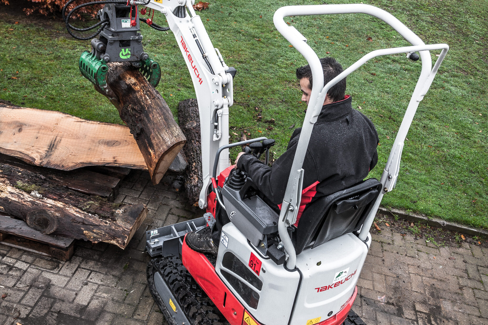 TB210R bovenaanizhct met houtstam in grijper