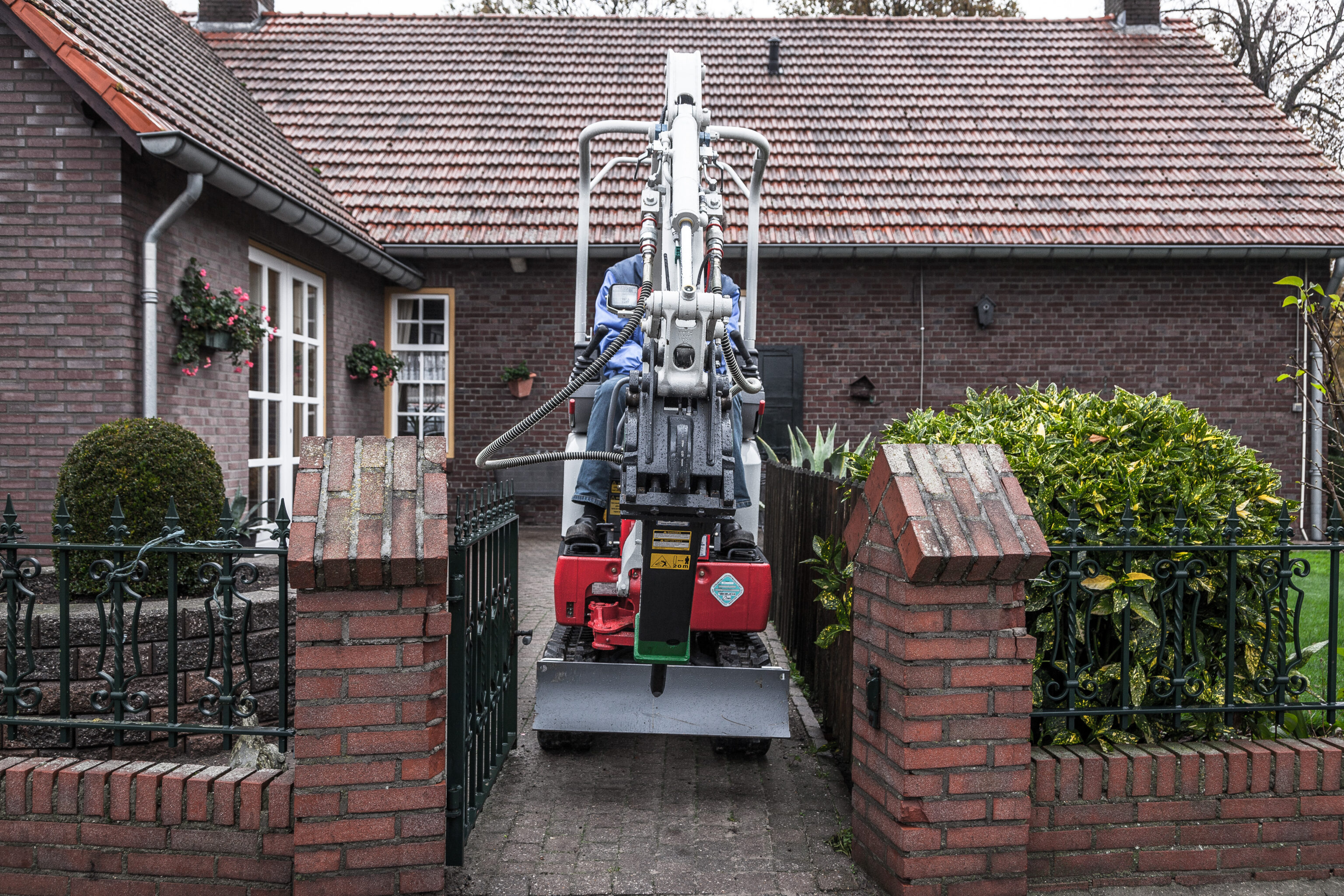 TB210R van voren in smalle tuin door tuinhekje