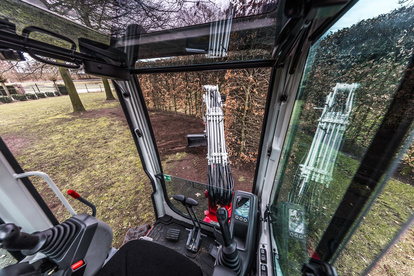 de ruime cabine van de Takeuchi TB225 met hoge voorruit