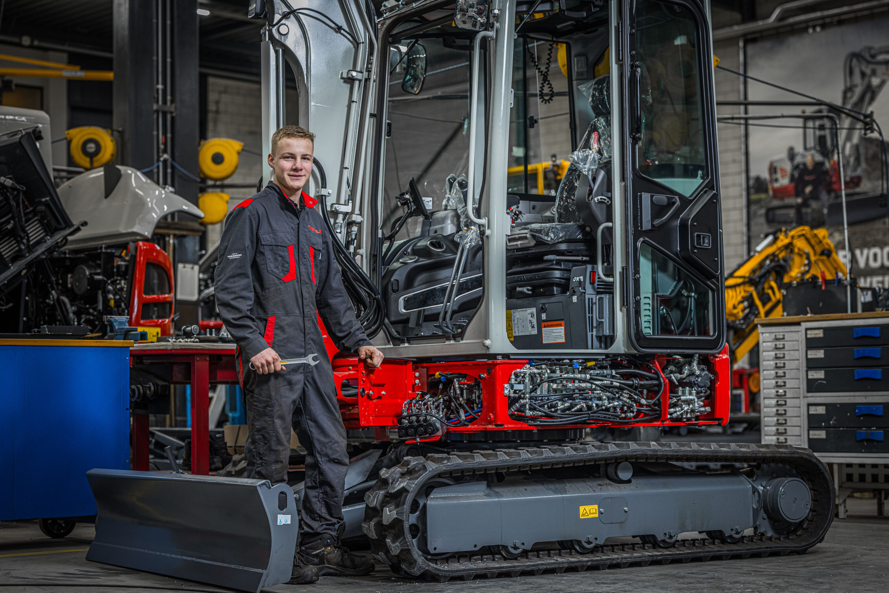 Takeuchi monteur poserend bij graafmachine