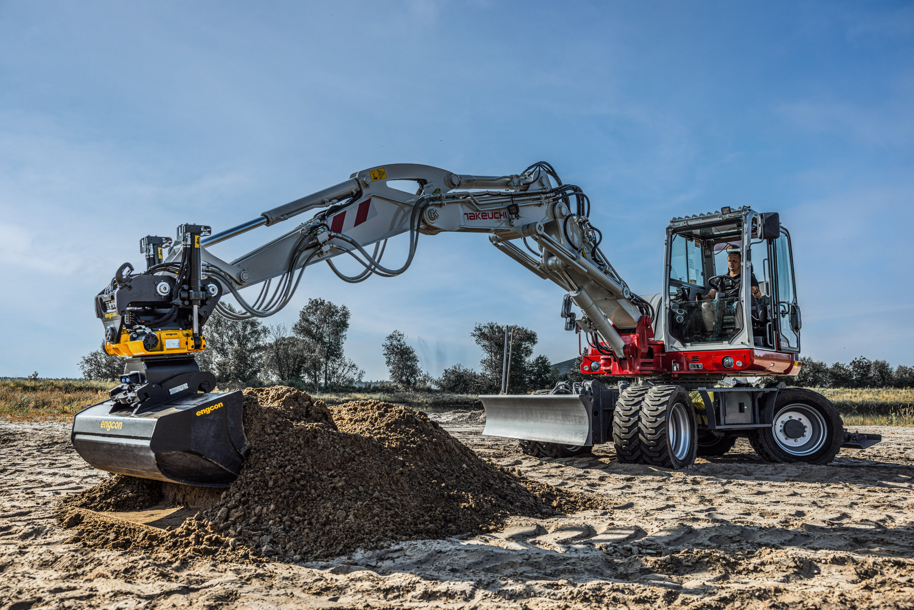 Een mobiele graafmachine van takeuchi met een draaikantelstuk aan de giek
