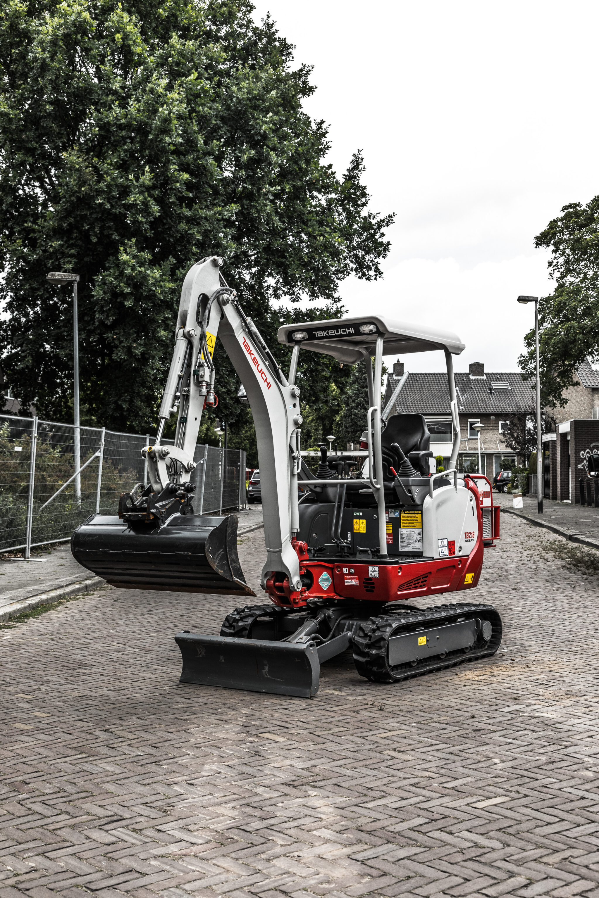 Hybride minigraver vrijstaand op de weg