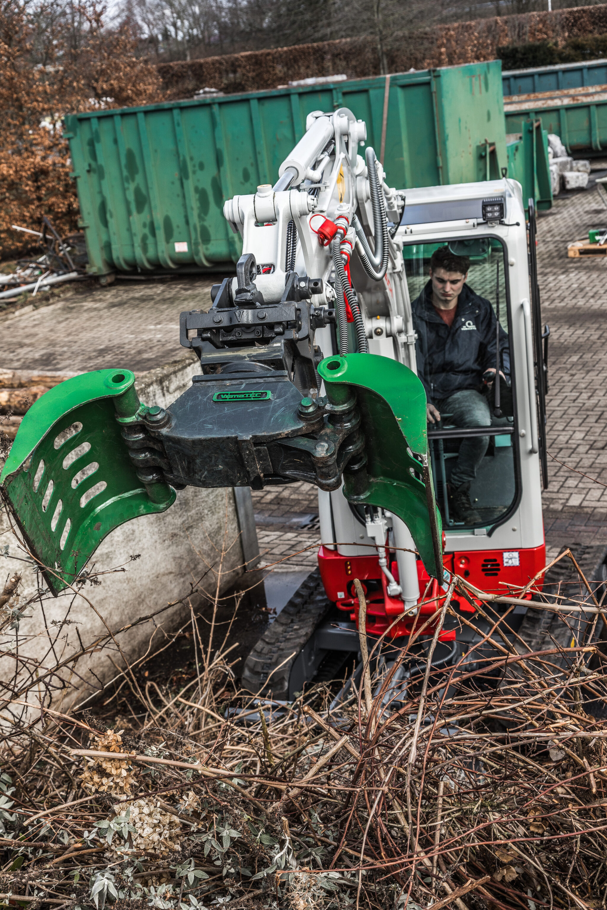 takeuchi graafmachine sorteert afval met een sorteergrijper