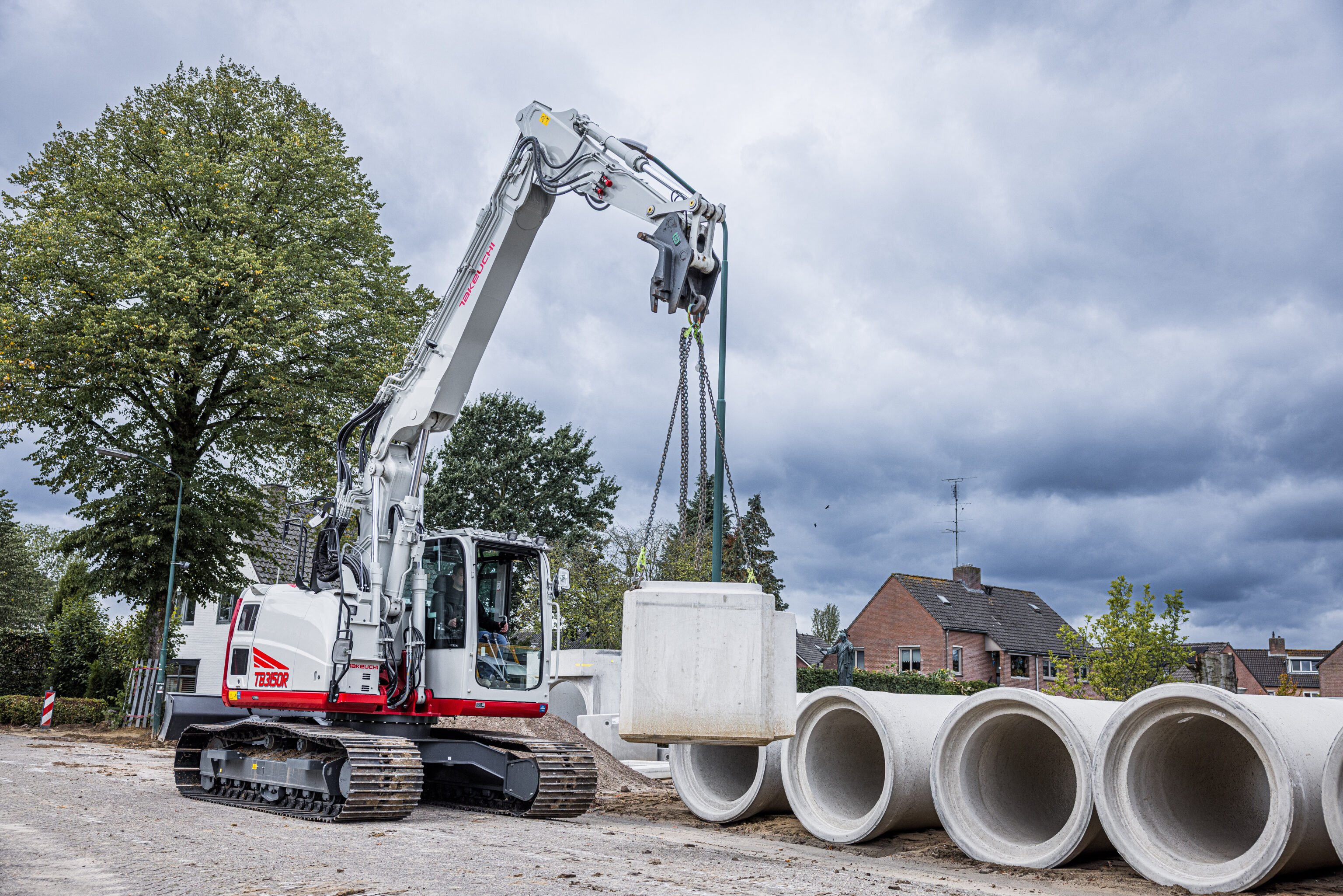 takeuchi tb3150r two piece boom hijst een zware betonblok